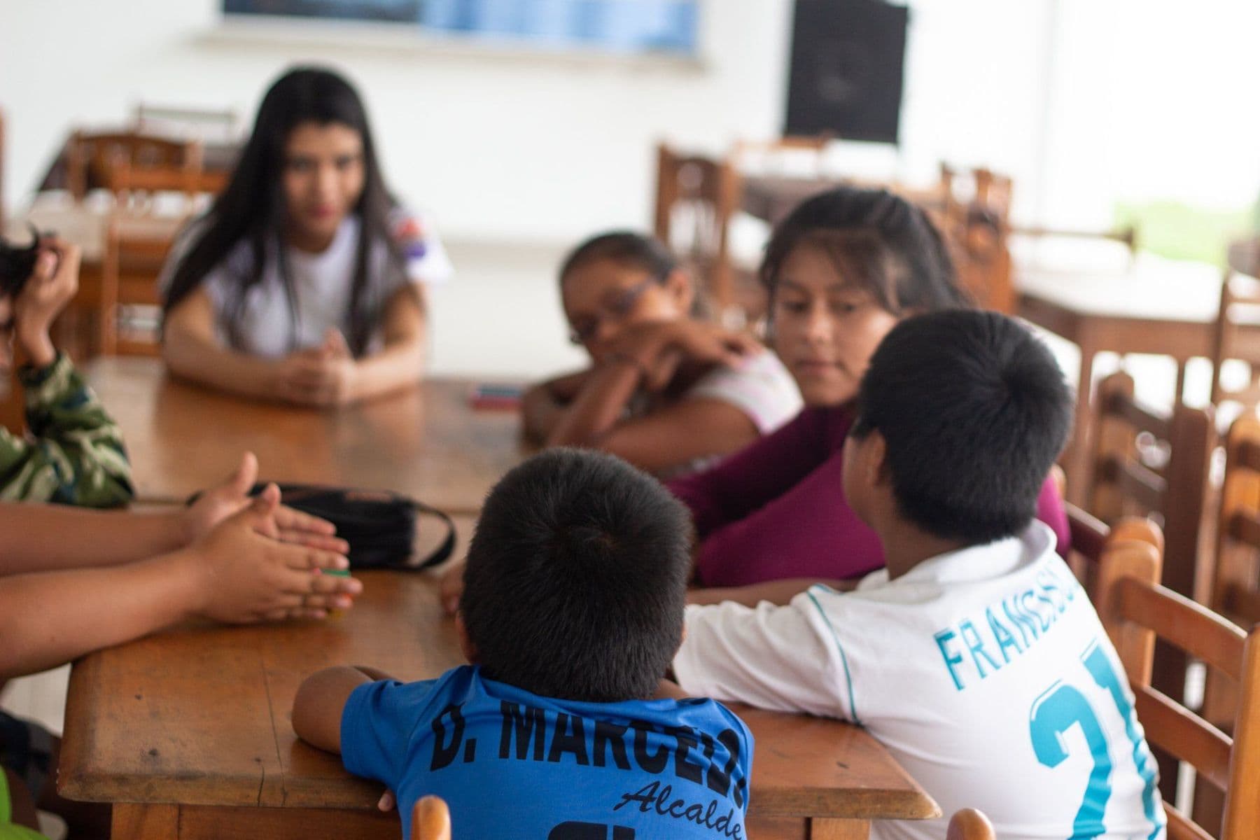 Children talking together around a table during a LitClub session