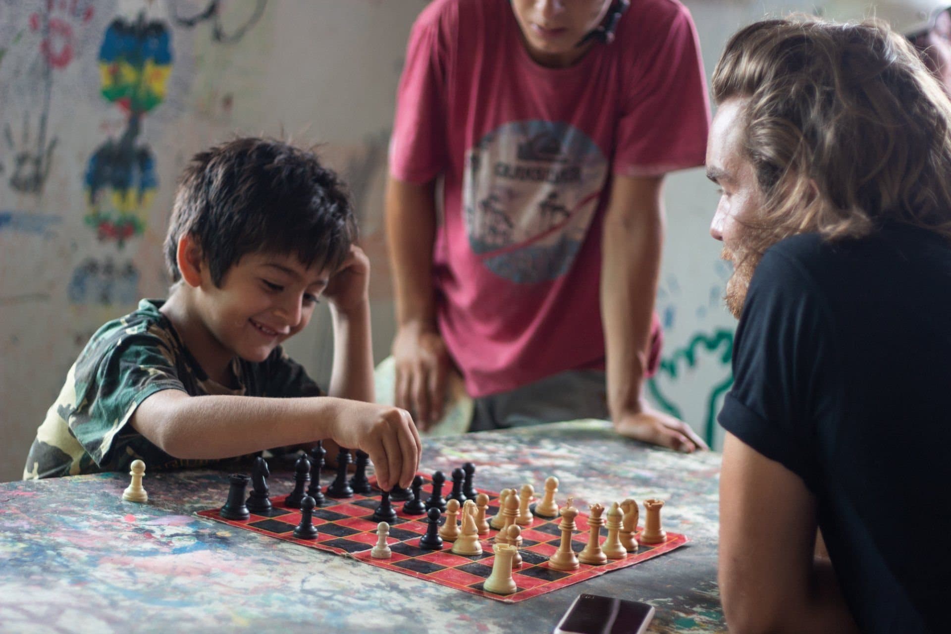 A volunteer and a child playing chess together