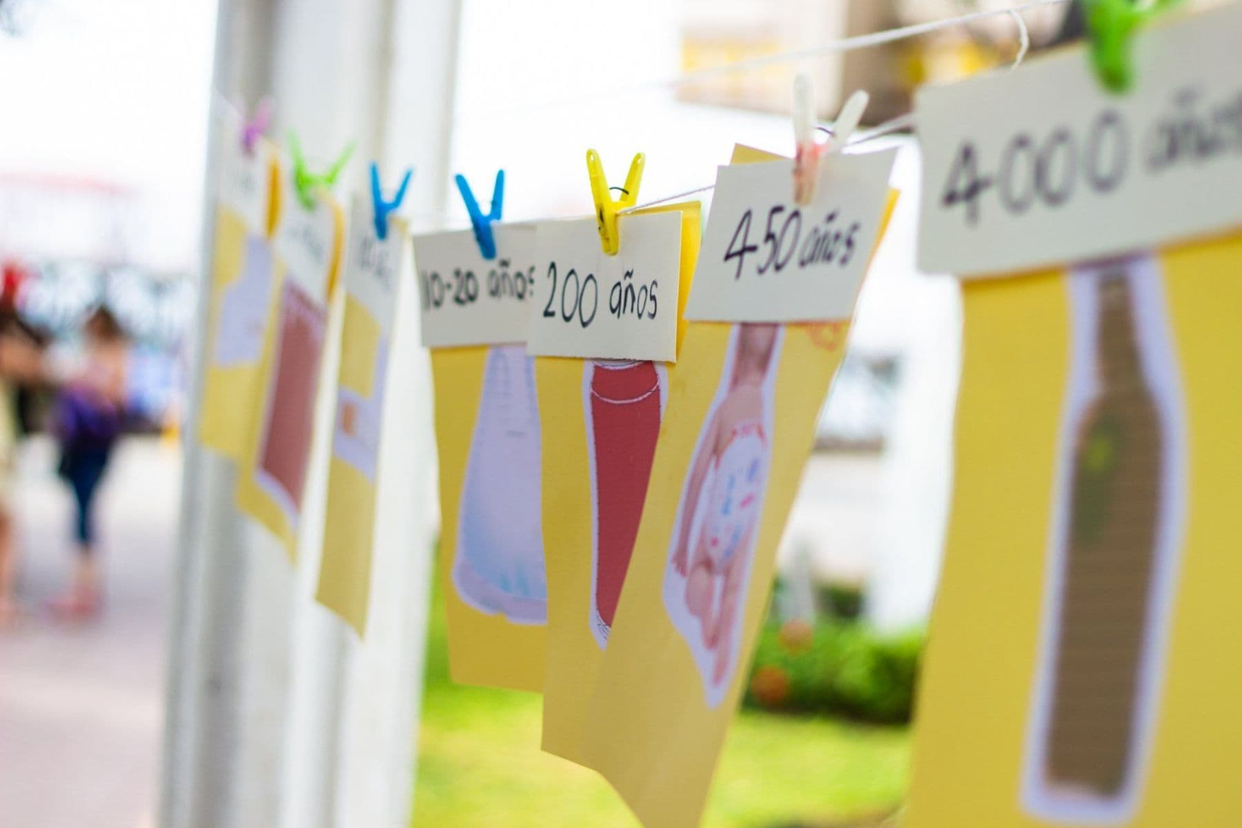 Cards on a washing line showing how many years different rubbish takes to break down