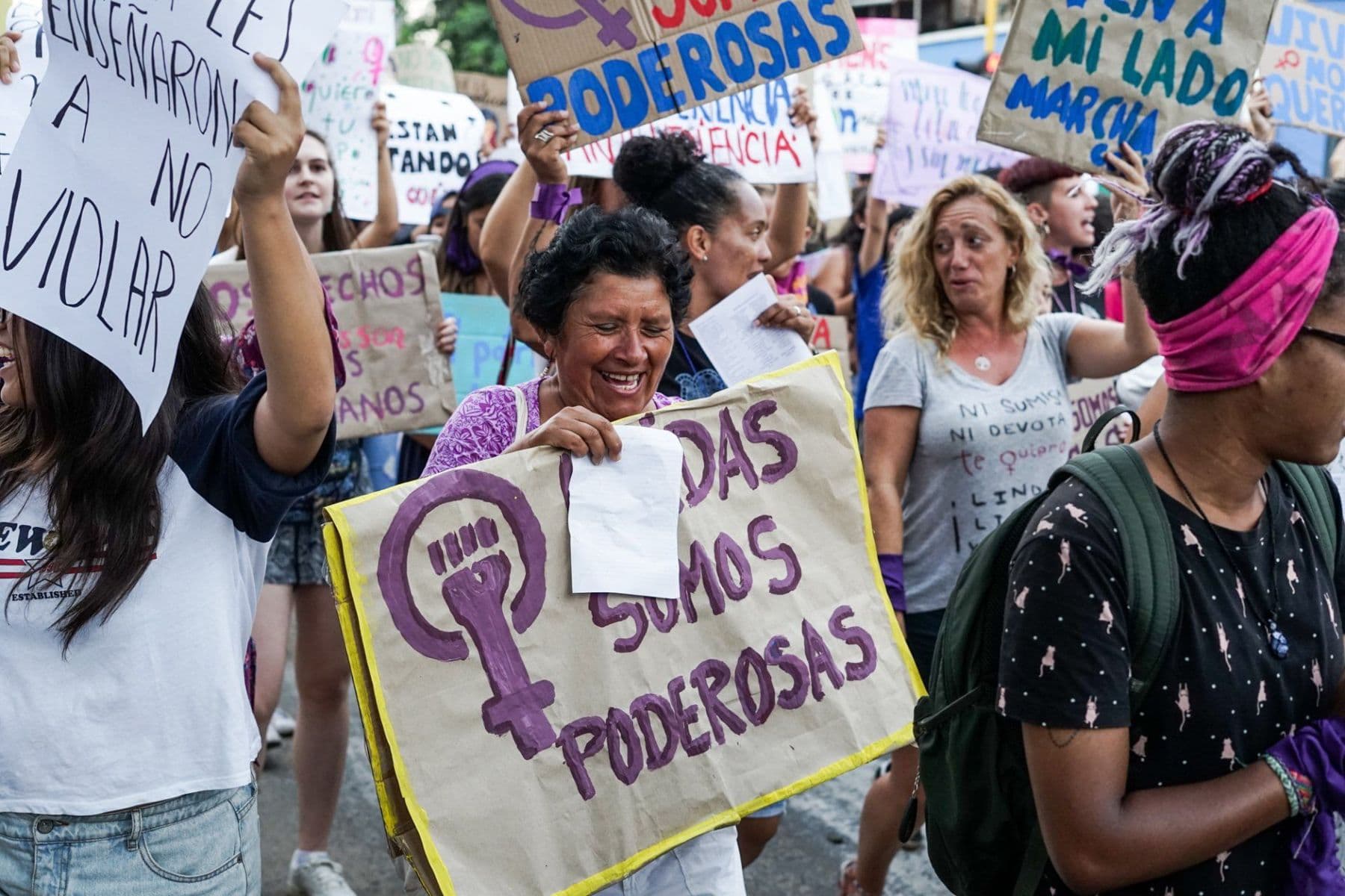 Women marching with hand-painted placards, one reading ‘Somos poderosas’