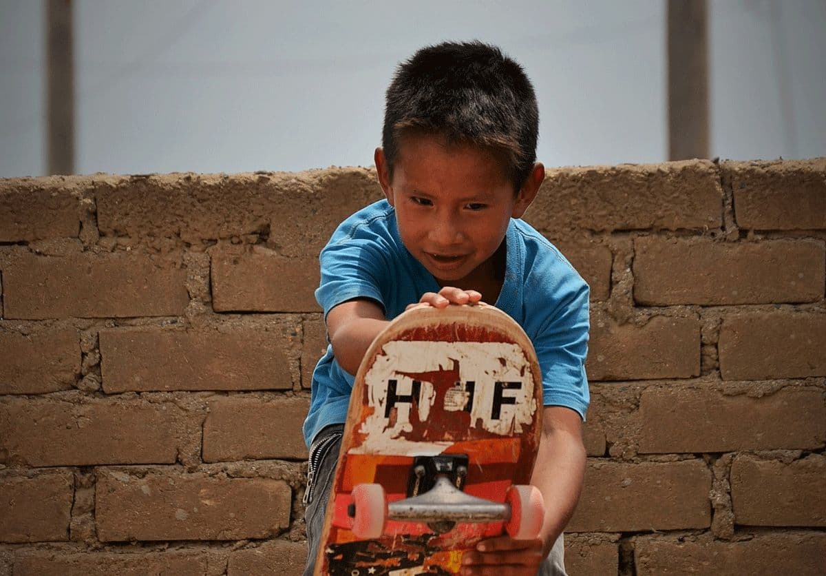 A child holding up a hand-painted sign at the original skate ramp