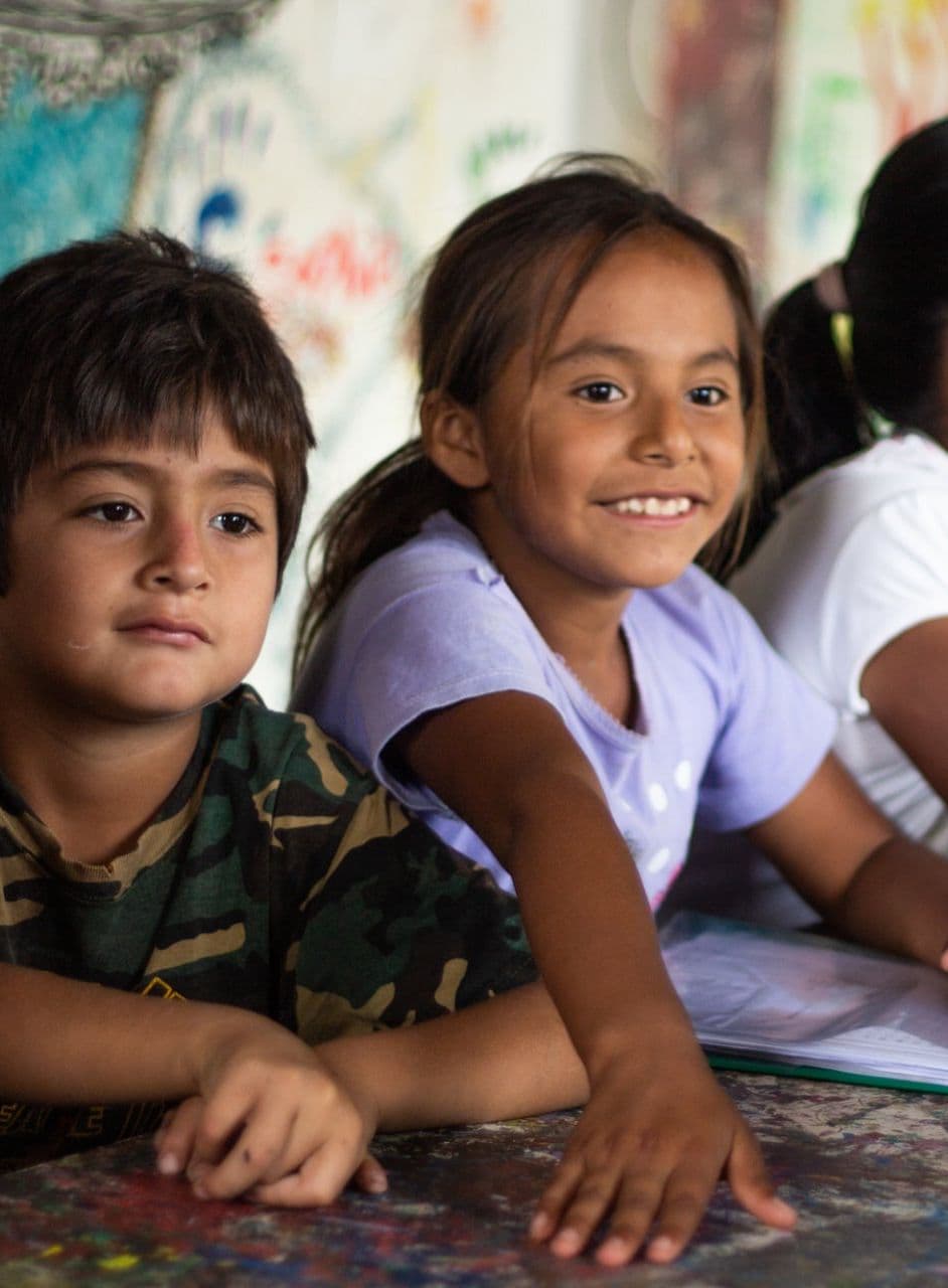 Two young children smiling at the camera during a class