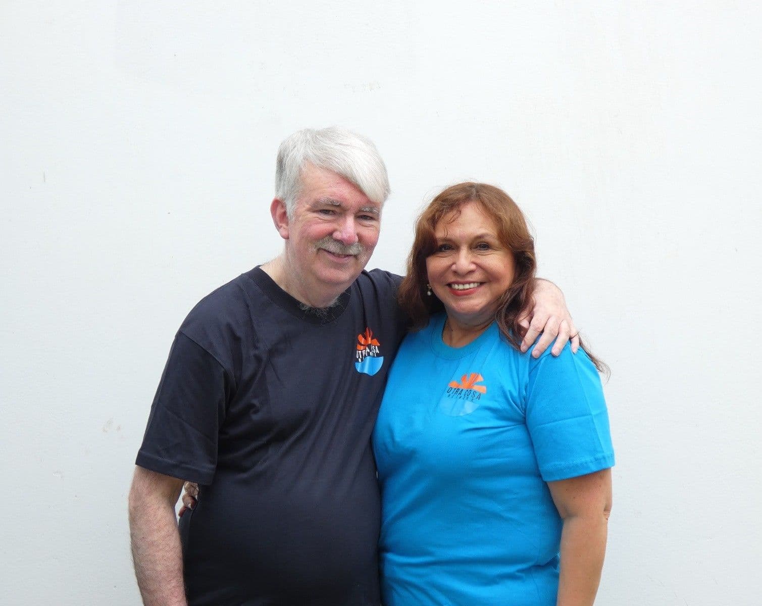 Peter and Juany Murphy standing arm in arm in Otra Cosa T-shirts