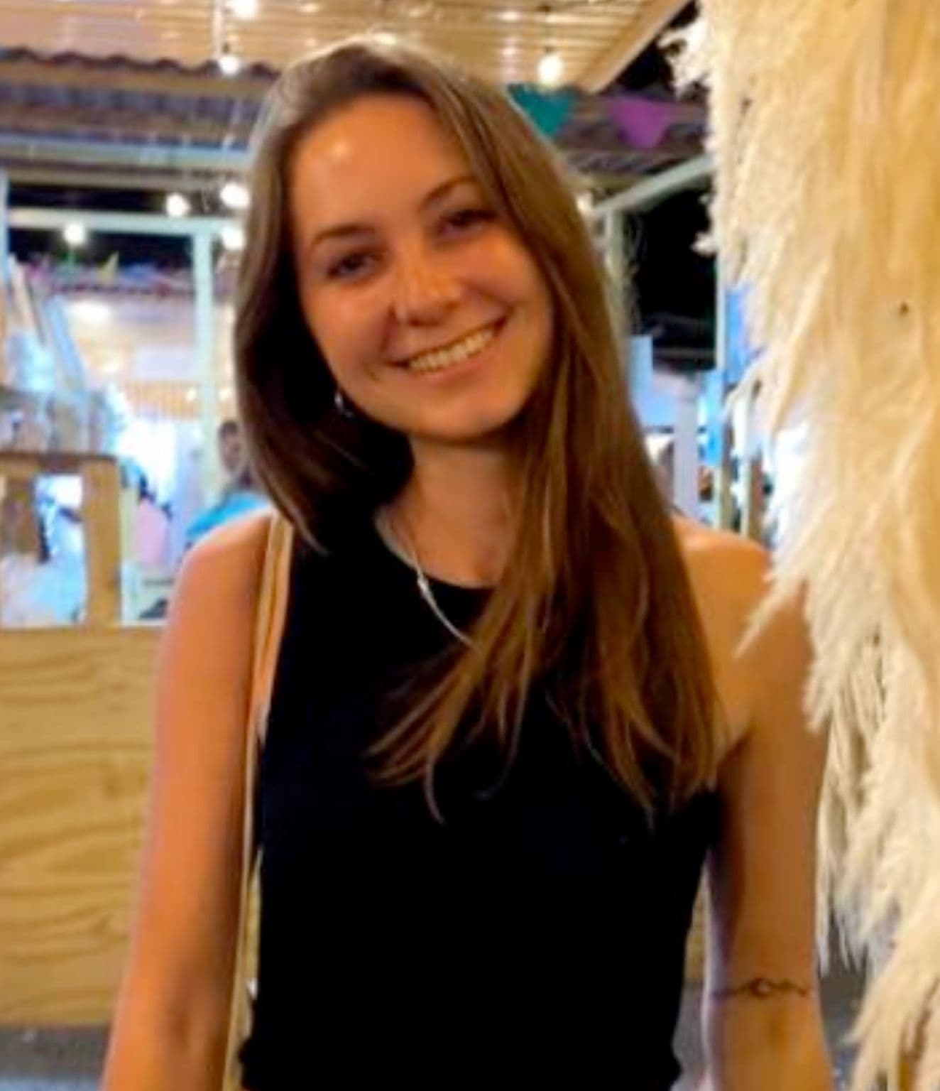 Millie Hodgkinson smiling, with long brown hair, wearing a black top