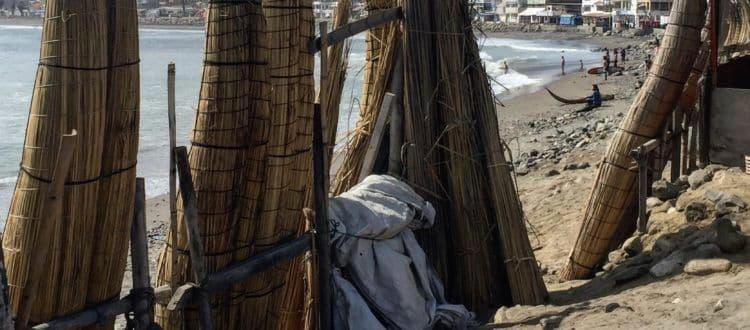 Caballitos de totora reed boats standing in a row on Huanchaco beach