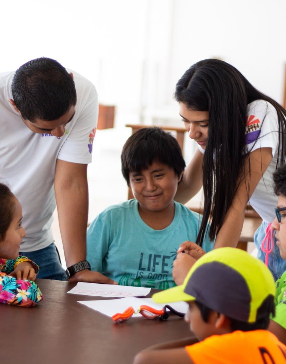 Otra Cosa volunteers helping children during a lesson